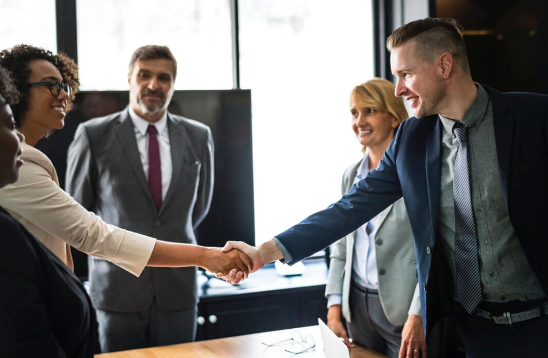 A group of people shaking hands in an office.